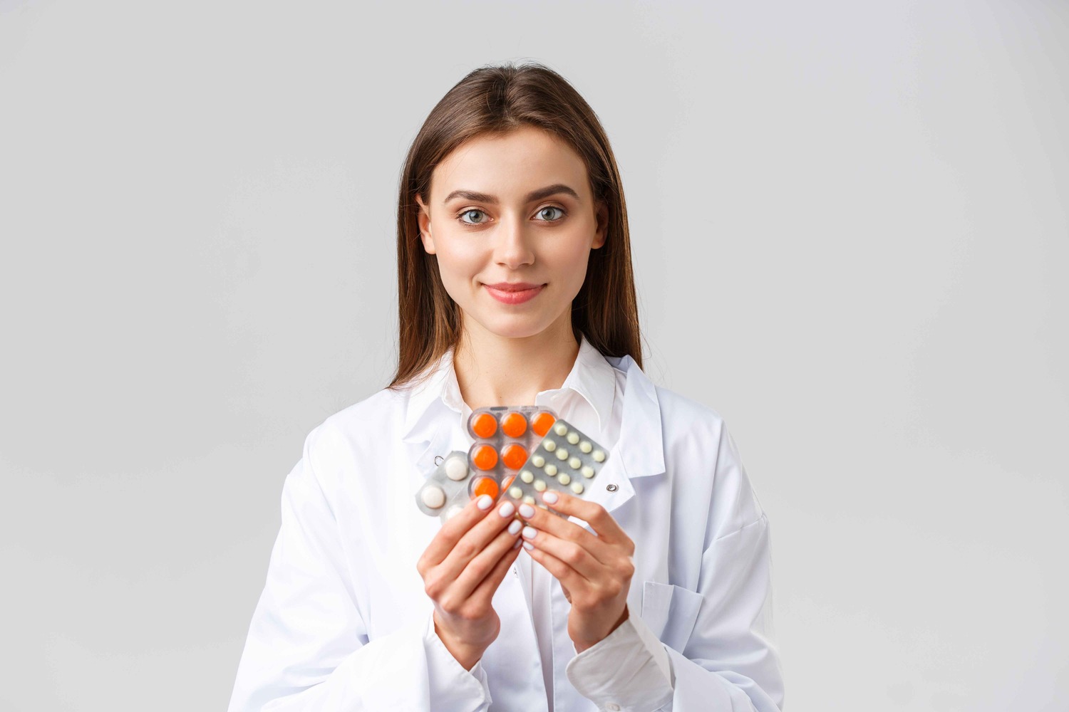 Female pharmacist holding pills in her hand