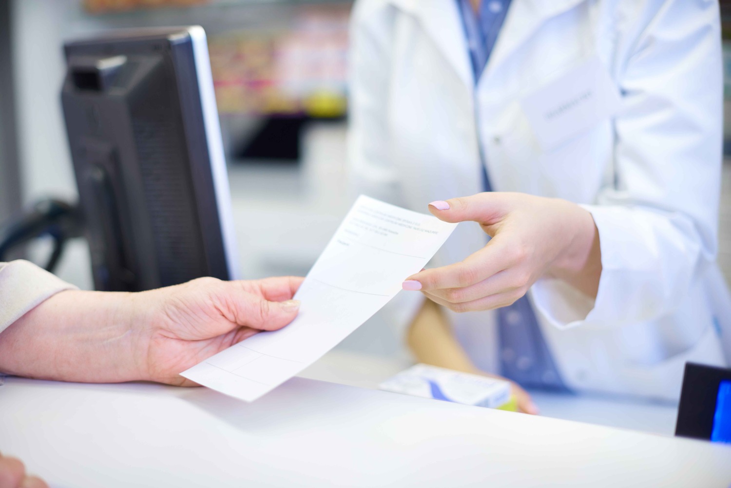 Hand giving prescription to pharmacist